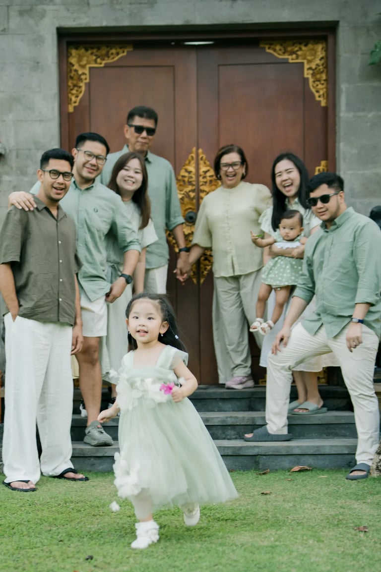 Large family gathered at a traditional Balinese entrance during a multigenerational family photography session in Bali.