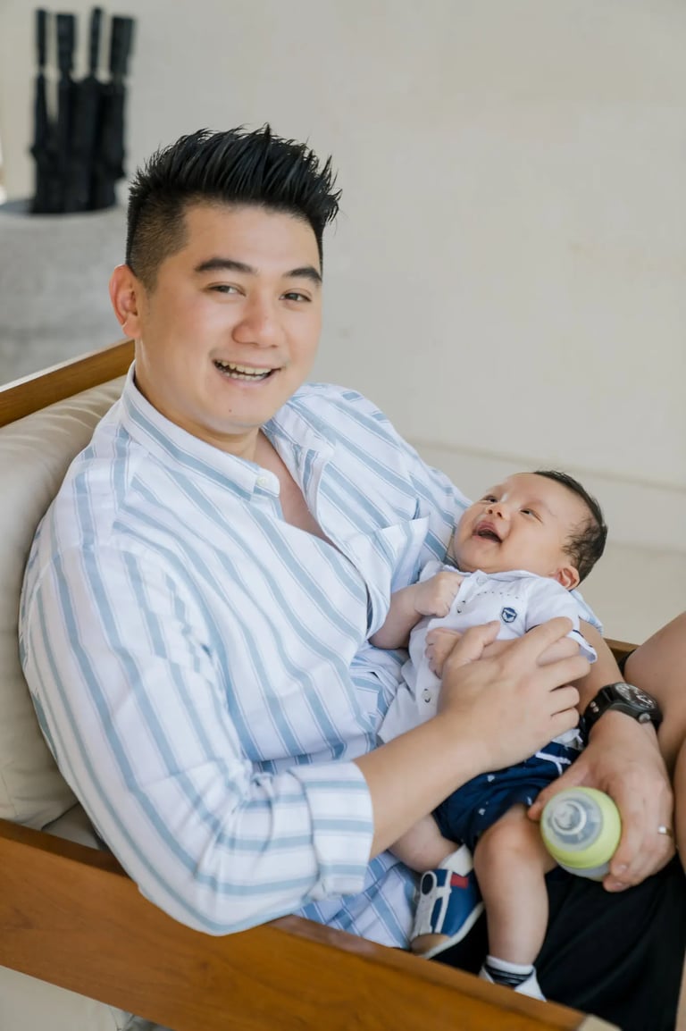 Father holding his baby during a family photography session at Samabe Bali Suites & Villas in Nusa Dua.