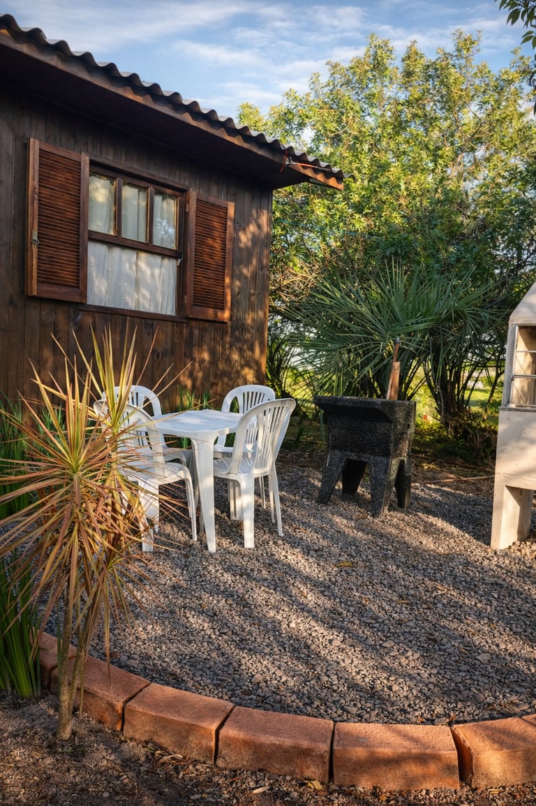 Área de lazer externa da cabana com churrasqueira, tanque e mesa.