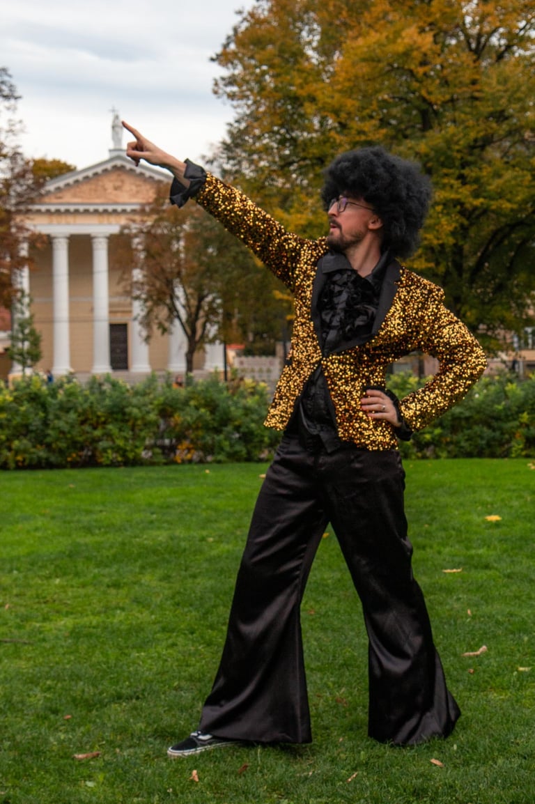 Blizgus aukso spalvos švarkas,juodos kelnės ir juodi marškiniai