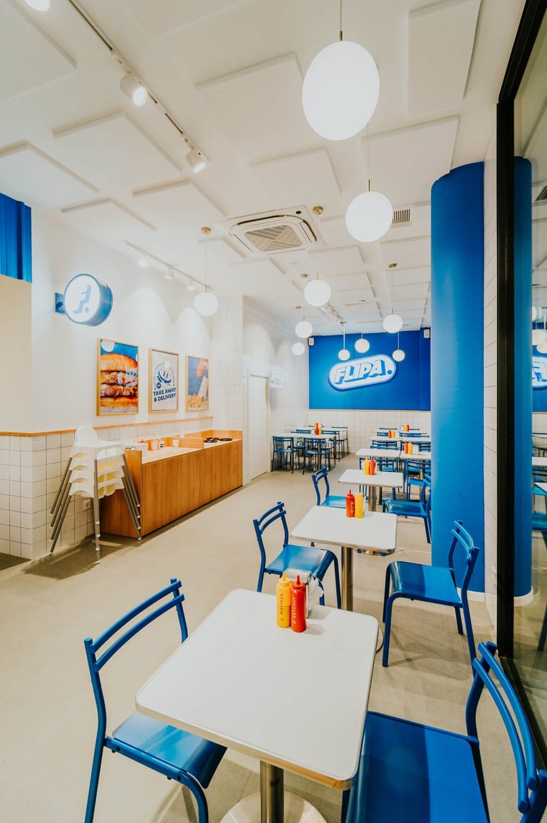 Interior del local de Flipa a Sant Martí, amb decoració retro i taules blaves