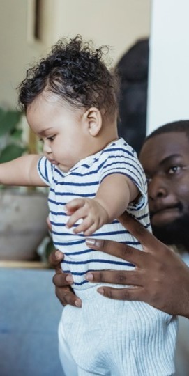 vader helpt met eerste stapjes