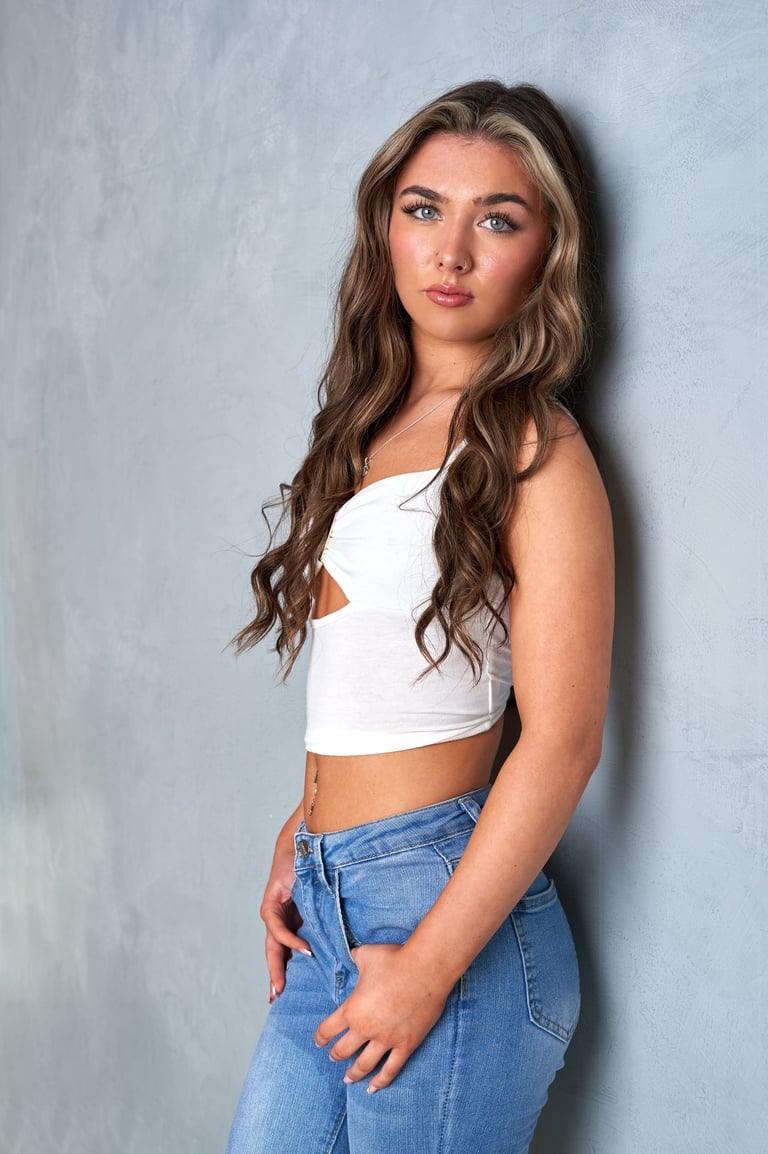 A model in a white crop top and jeans