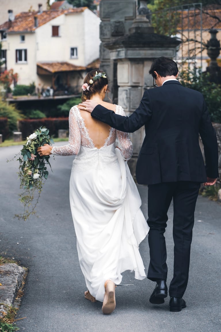 Couple de jeunes mariés de dos qui marchent ensemble