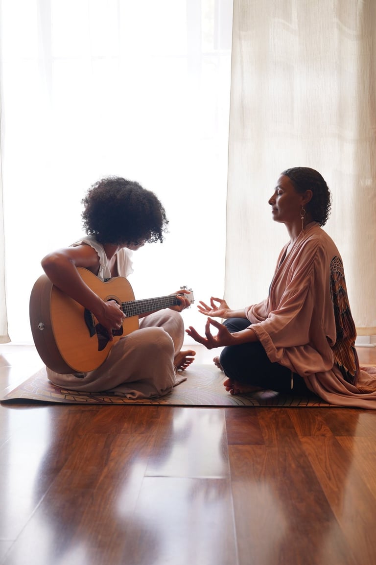 a woman sitting on a mat with a guitar and a guitar