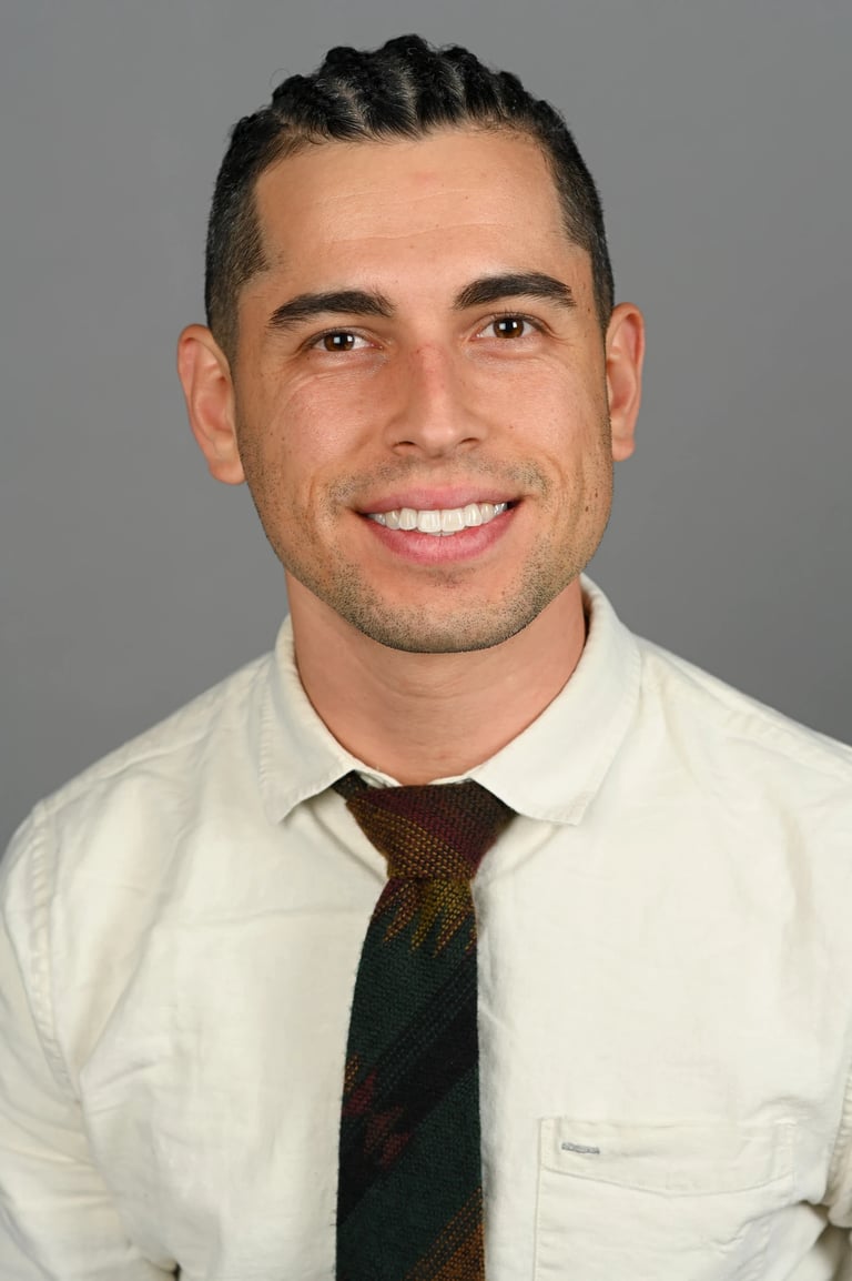 Daniel Alvarez in a cream shirt and tie 