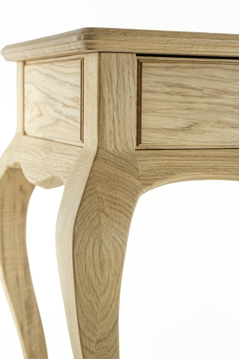 Close-up of a handmade oak console table showing the curved leg and side panel