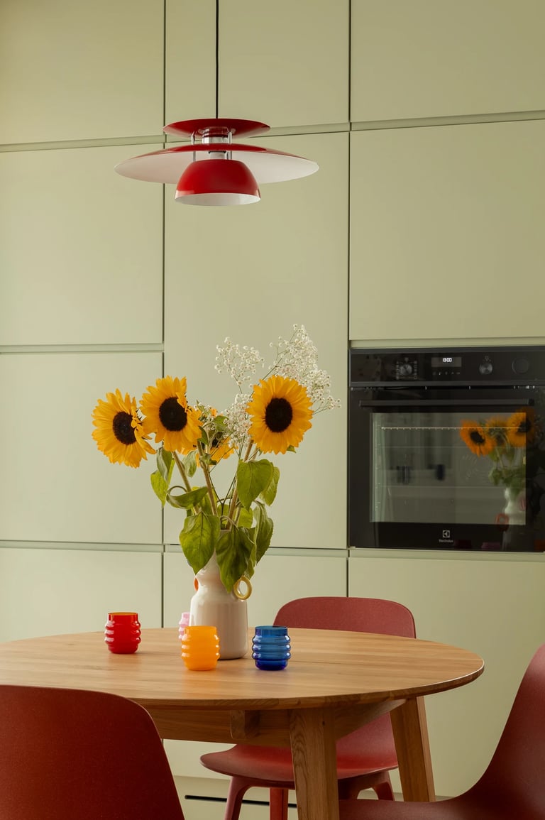 Kompozycja kadru: detale na stole w jadalni i designerska lampa.