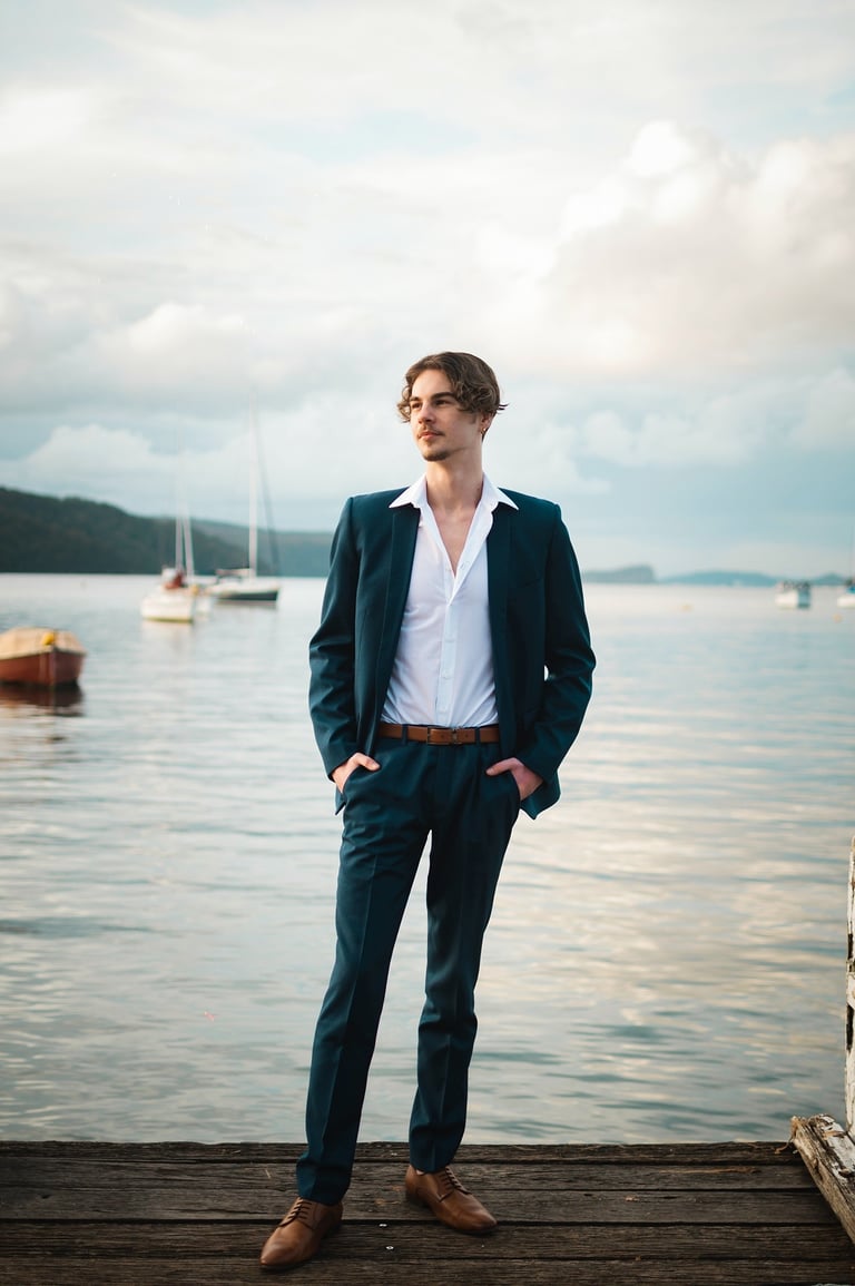 a man in a suit and tie standing on a dock