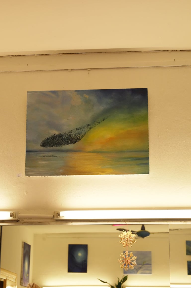 Impressionist oil painting of a dark cloud over a sunset ocean landscape hanging on a white wall.
