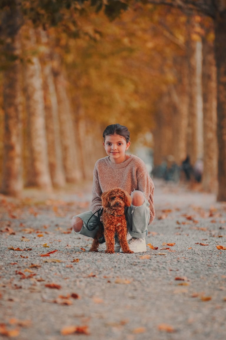bambina col proprio cane marrone sulle mura di Lucca in autunno