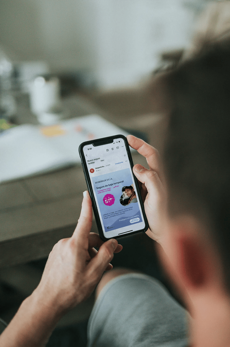 Un chico sujetando un móvil en la mano