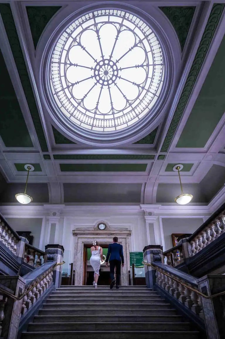 bride and groom walking up the main stairs at Islington Town Hall