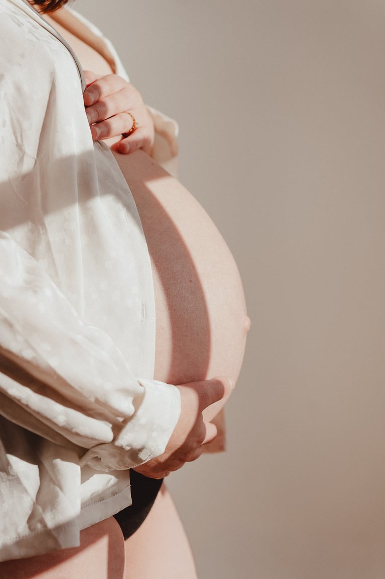 Femme enceinte tenant son ventre portant une chemise