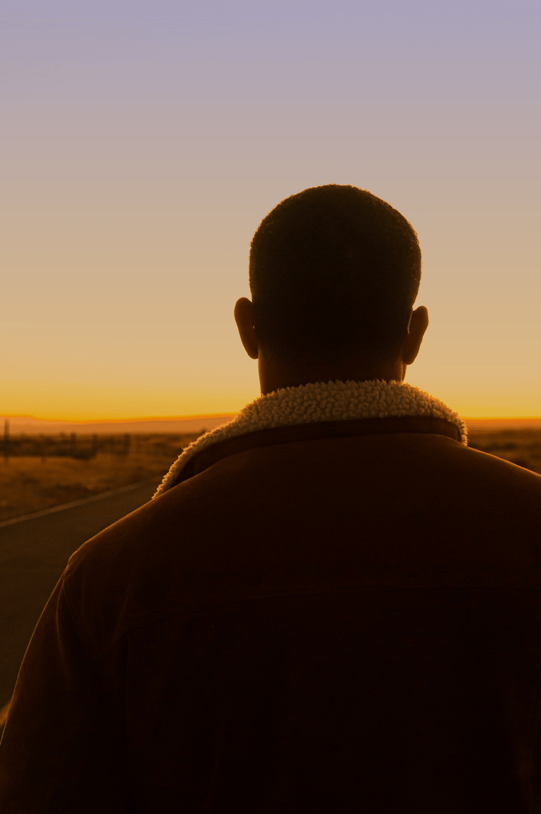 Joven mirando a lo lejos en una carretera mientrás reflexiona acerca de lo que busca en la vida