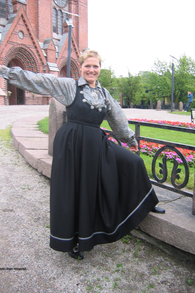 A woman in a black dress standing outside a church