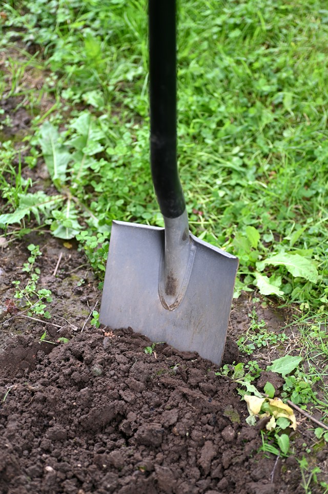 a person digging up soil with a showel