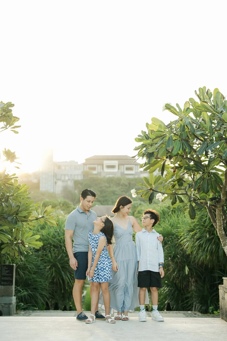 Family standing together on a resort pathway during a luxury family photography session at The Ritz-Carlton Bali.