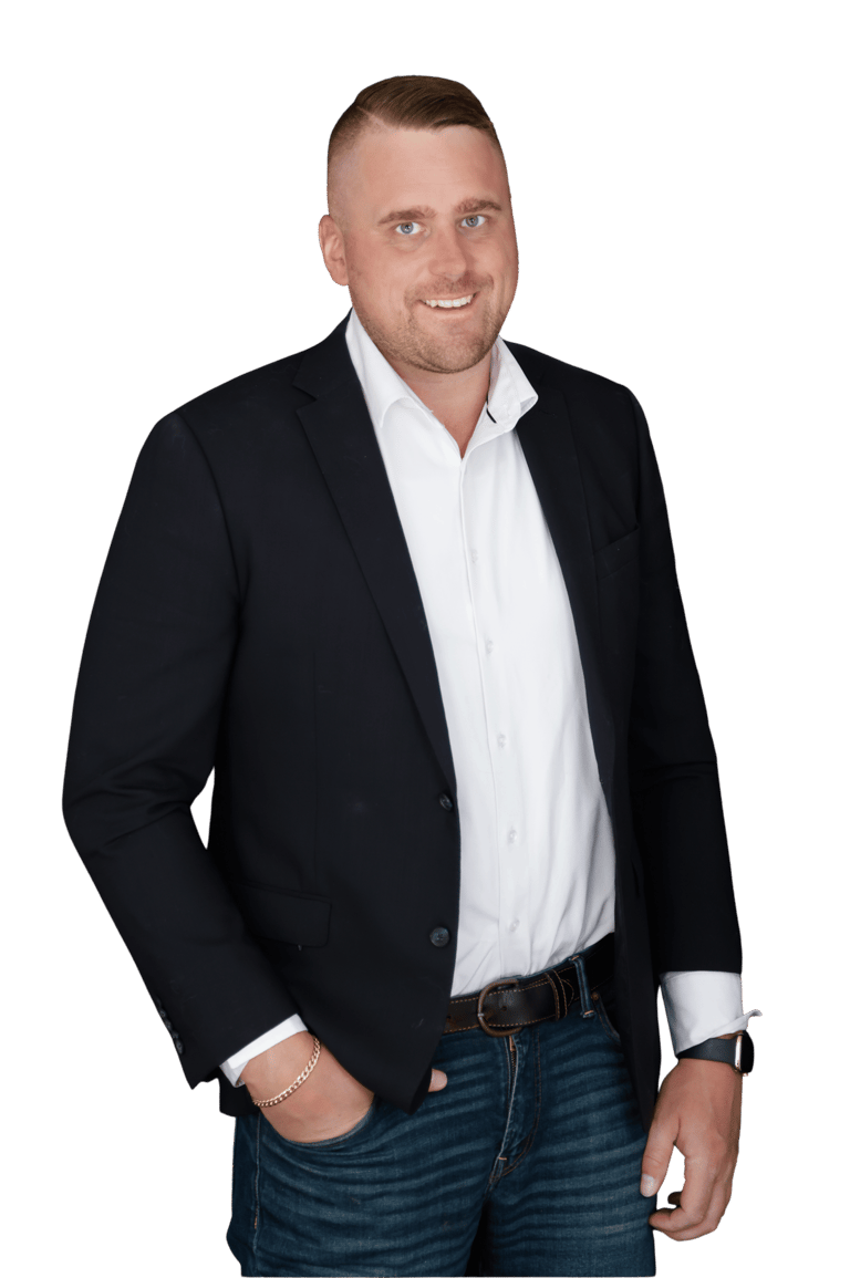 Riley Chisholm in a black blazer and white shirt posing for a business headshot.
