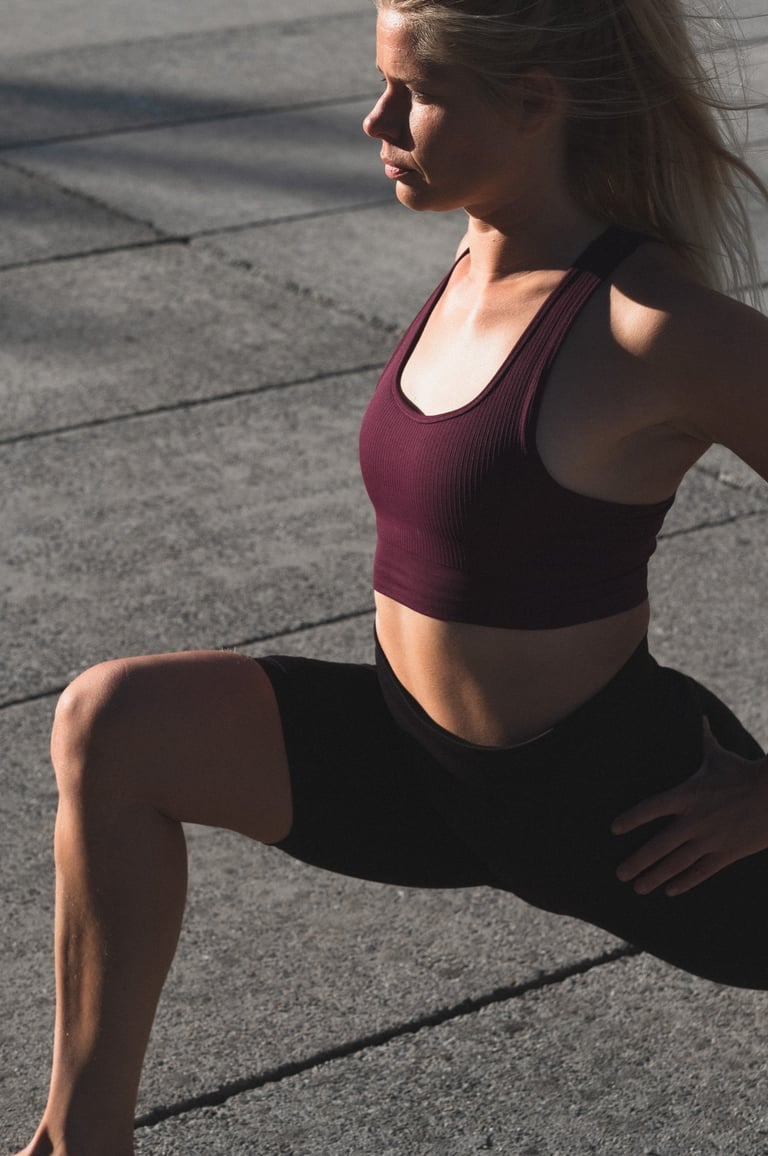 Vrouwelijke personal trainer doet pilates stretch op een plein in Gent