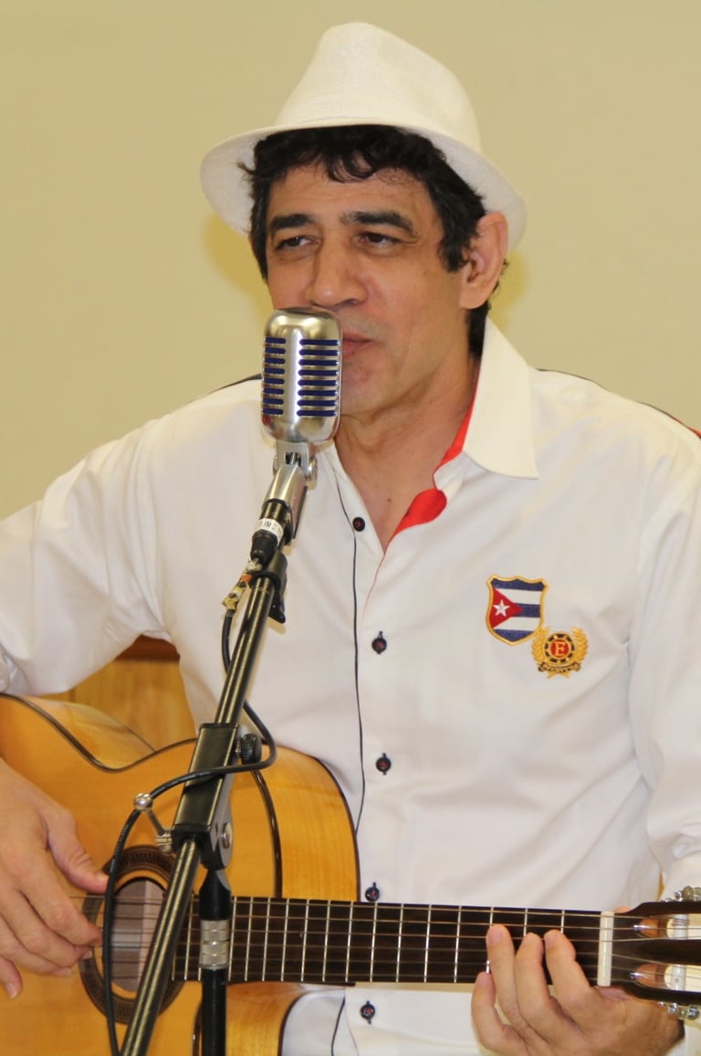 Maestro Bobby Ramirez playing guitar and singing Cuban music