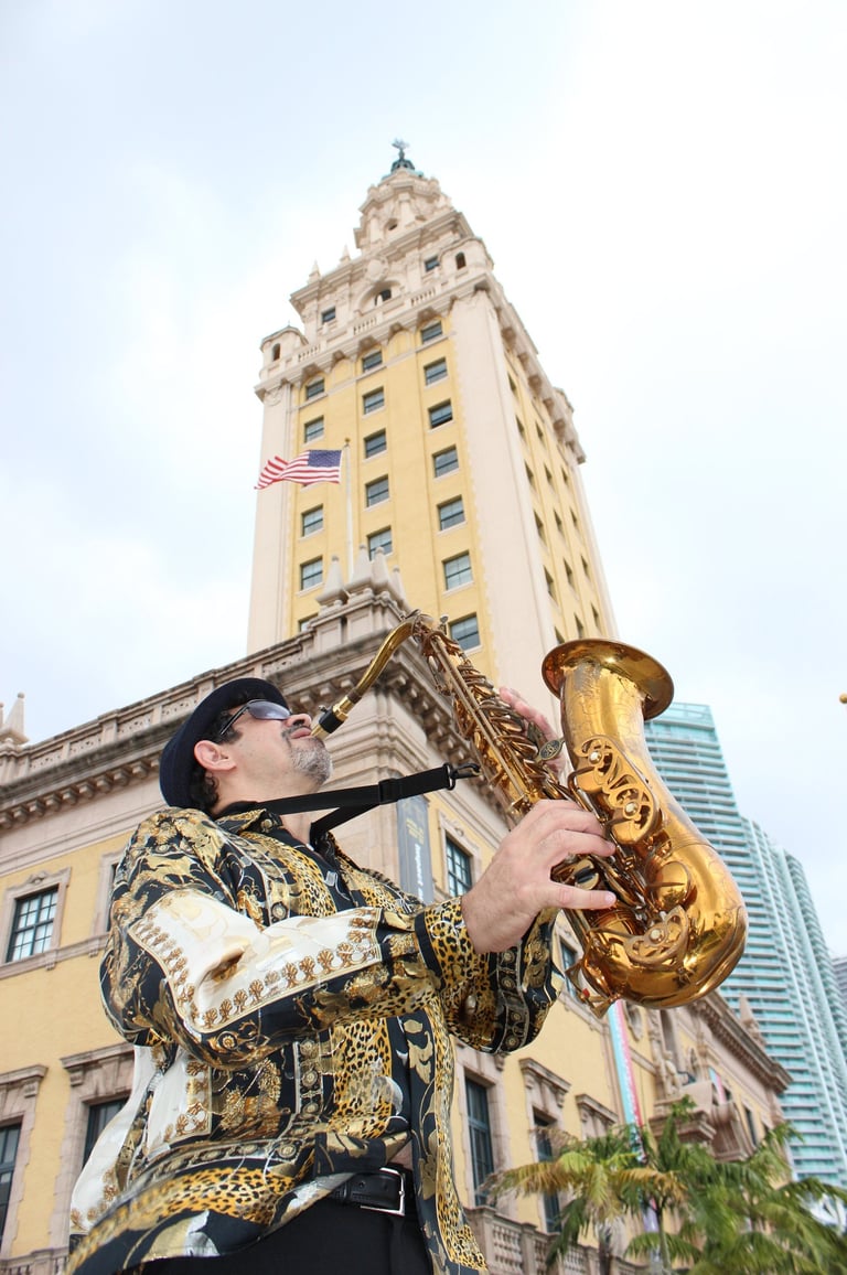 Bobby Ramirez playing the saxophone in front of Freedom Tower Miami