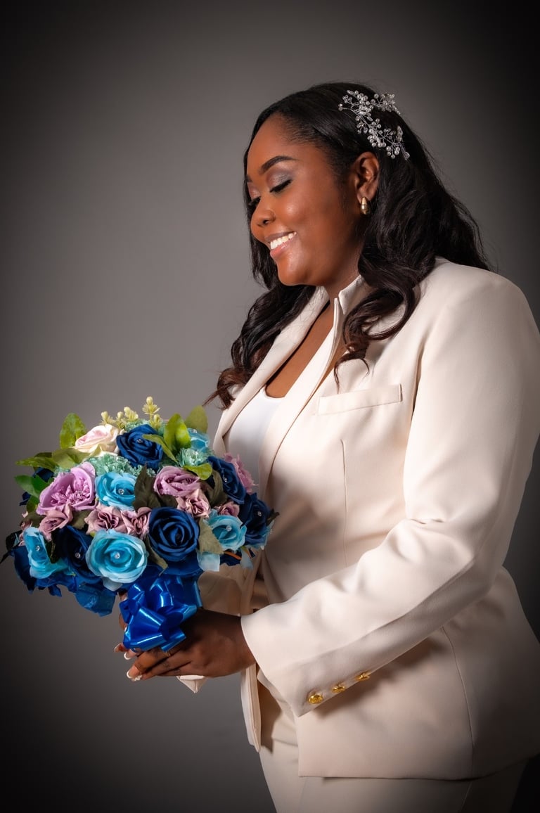 a woman in a white suit and a bouquet of flowers