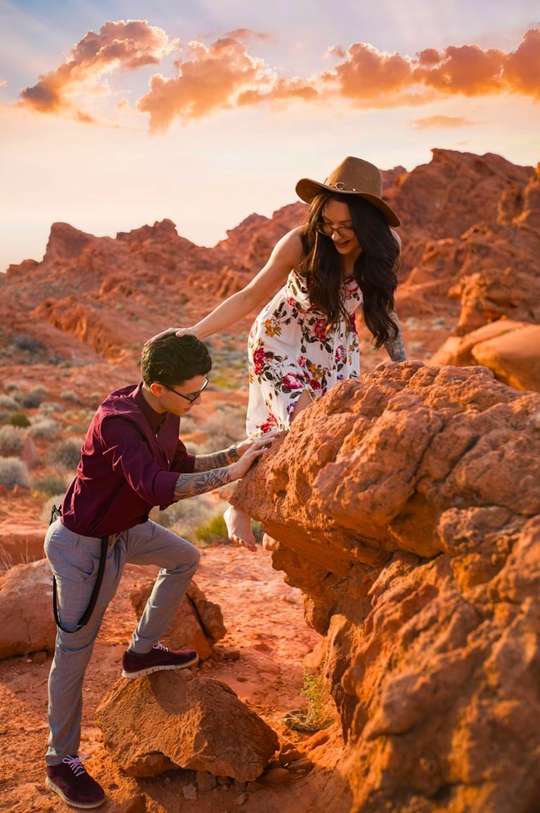a man and woman holding hands on a rock