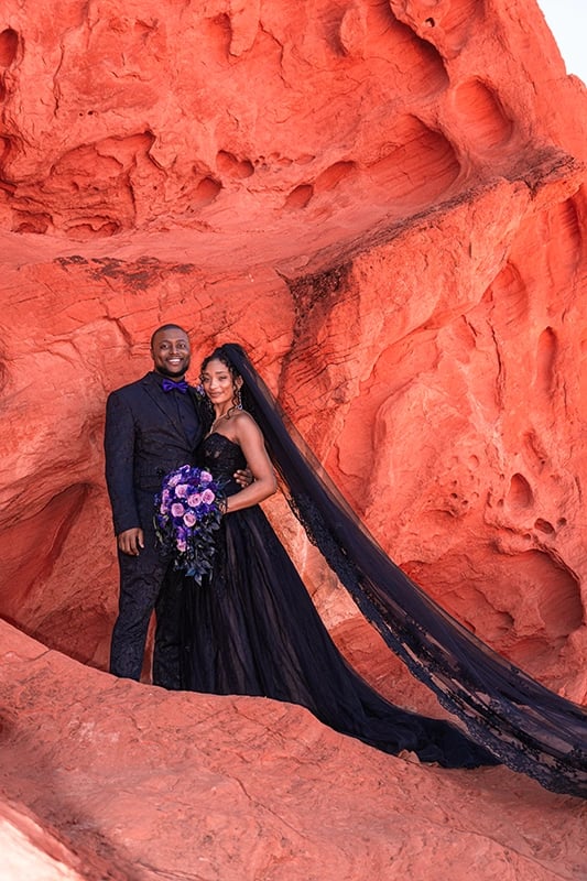 a man and woman in black wedding dress and veil
