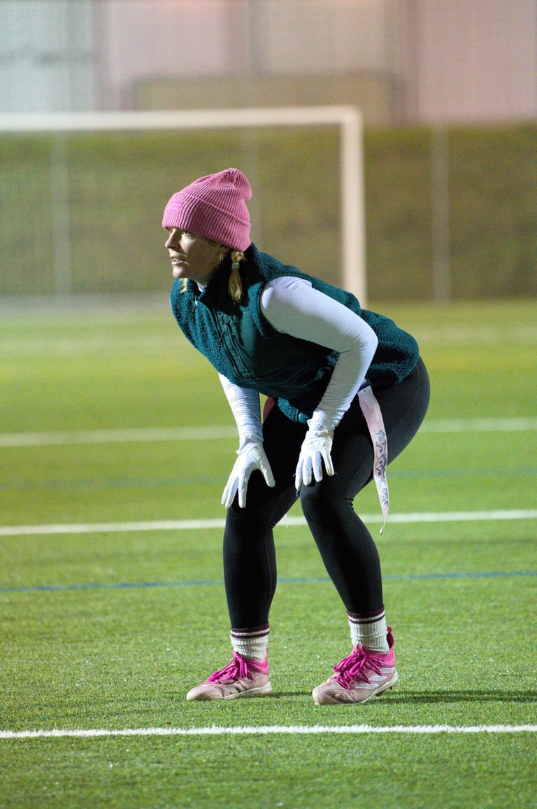 Flag Football Defensivspielerin Luca Alex von Limmat Lightning in Backpedal-Position im Training.