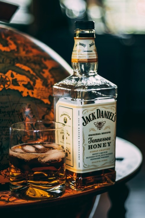 Bottle of Jack Daniels and a glass of whiskey on ice