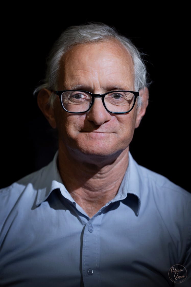 a man with glasses and a blue shirt
