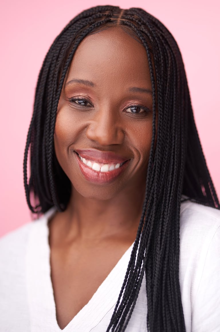 Headshot of Tracie Frank with a warm smile and long braids