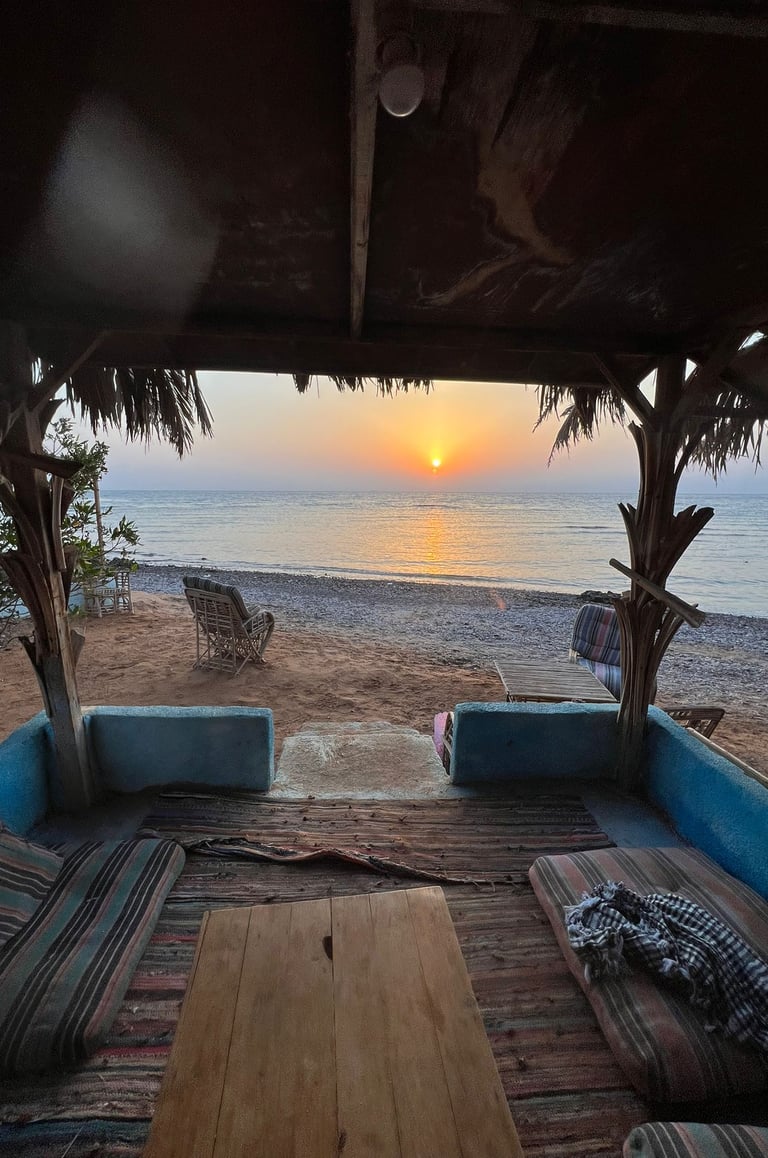 En terrasse til et populært strandrom med en sofa med bord og stoler foran en strand