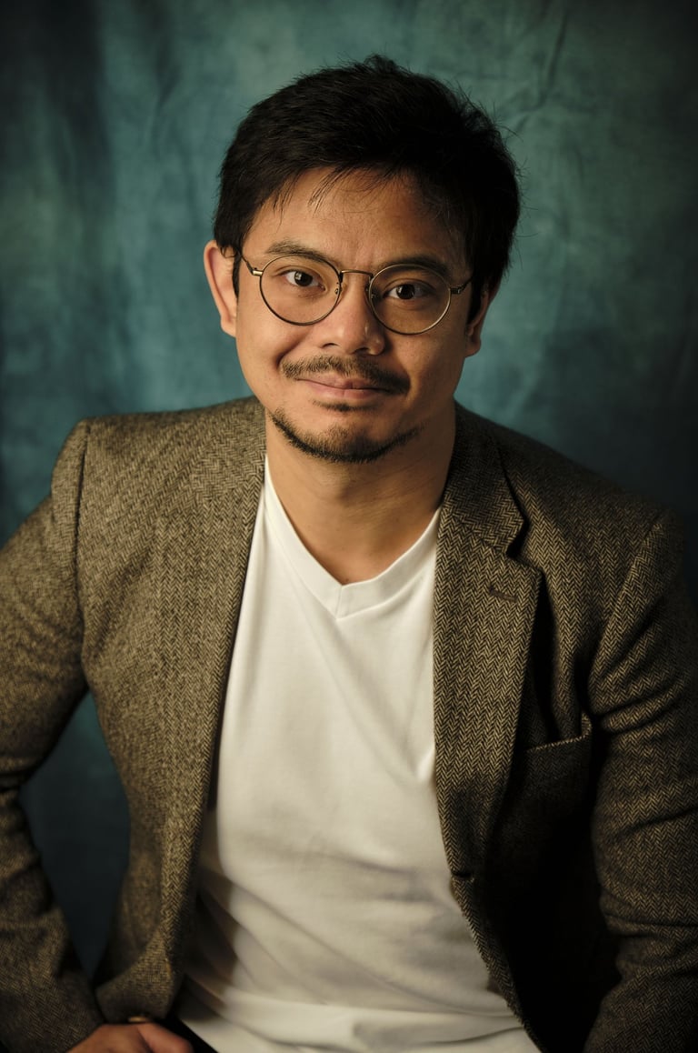 a man in a suit and glasses poses for a portrait