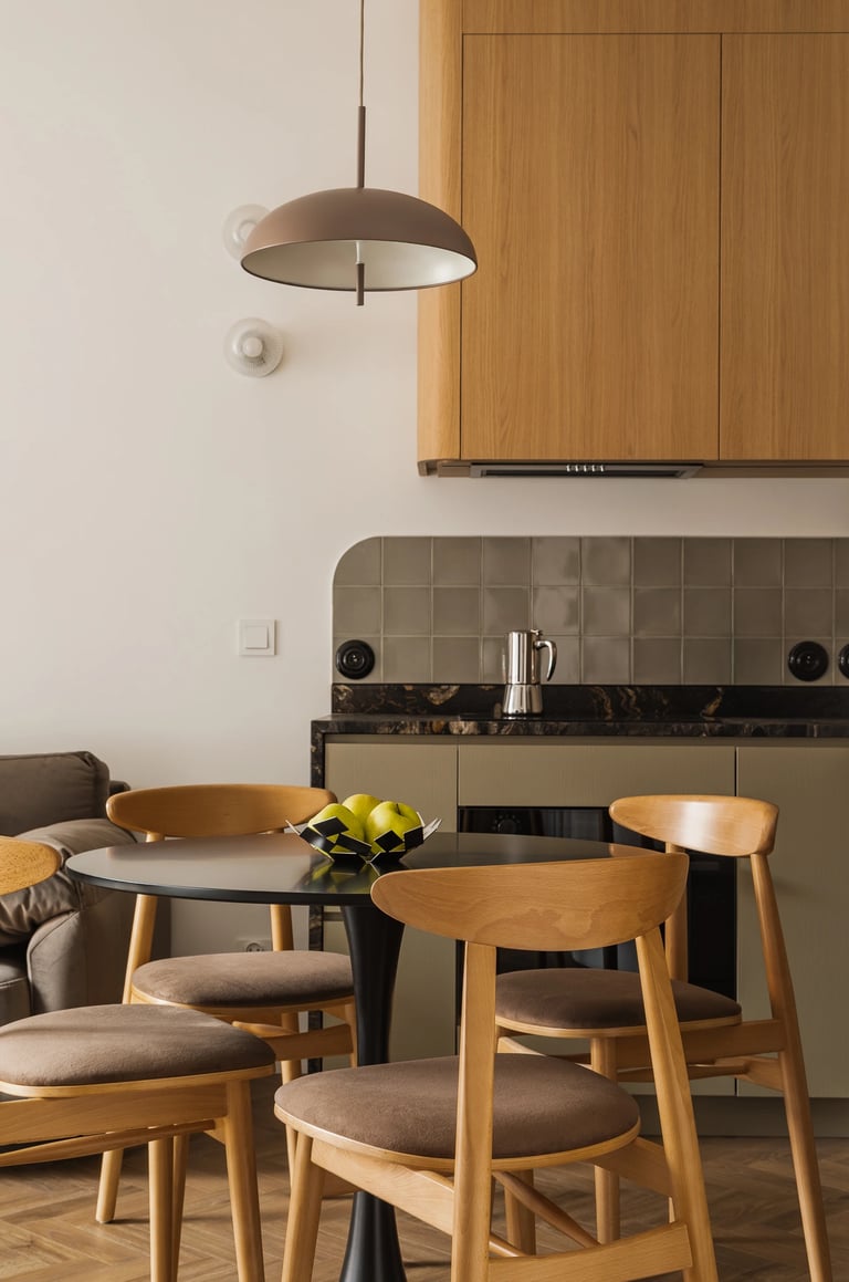 Fotografia wnętrz jadalni i kuchni. Nowoczesny stół, krzesła i drewniana zabudowa.