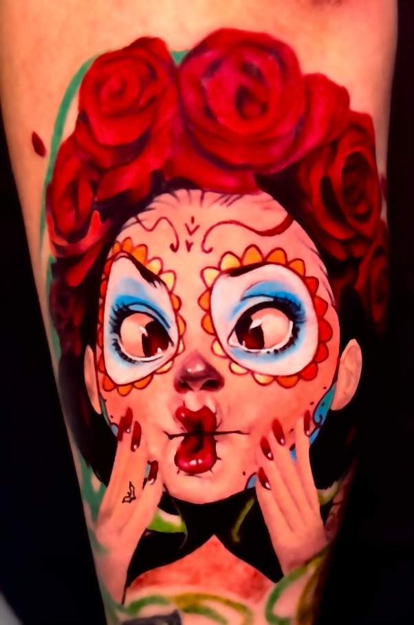 Vibrant Day of the Dead sugar skull girl tattoo with red roses and colorful face paint.