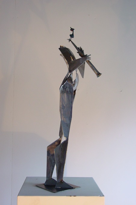 a sculpture of a man playing a wind instrument