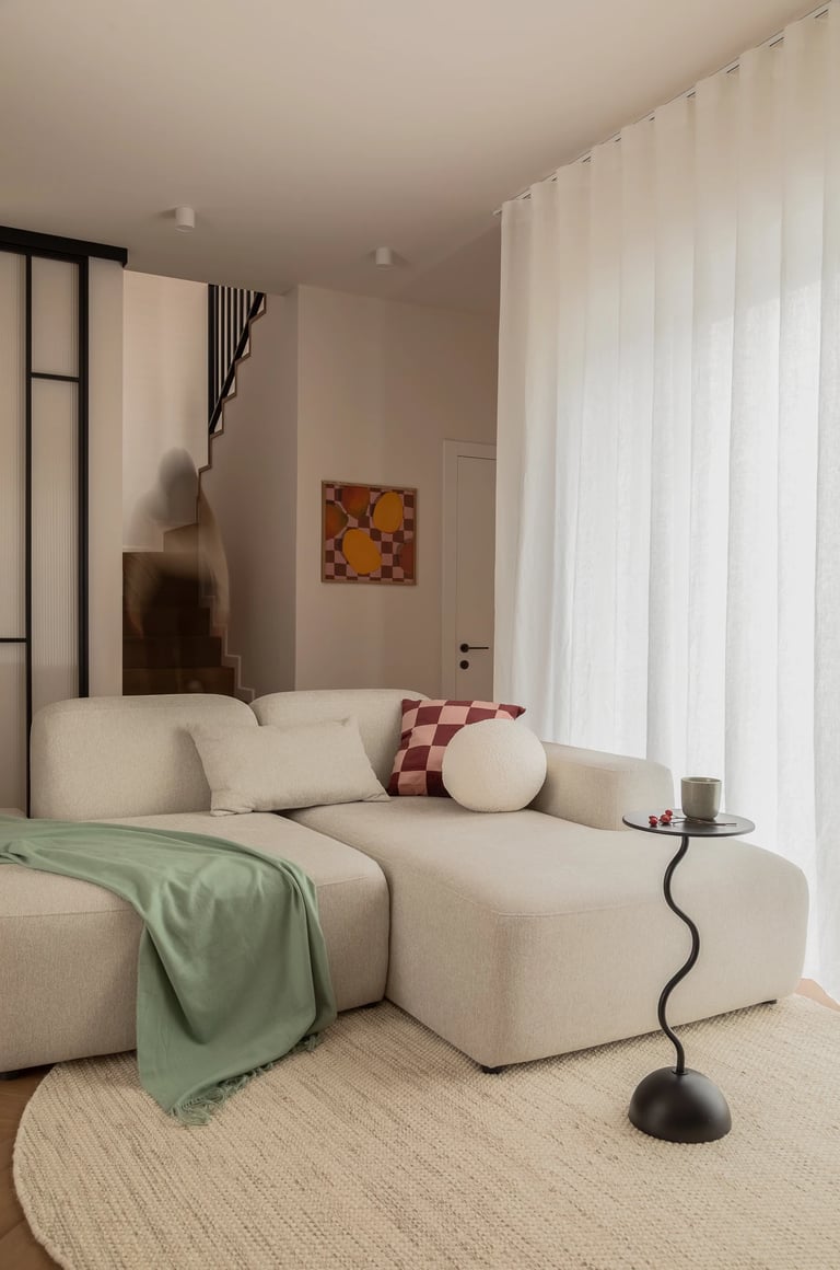 Jasny salon, beżowa sofa bouclé i czarny stolik. Fotografia wnętrz.