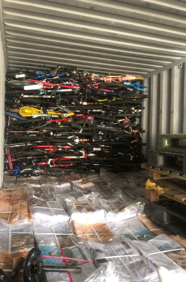 old newspapers, used bicycles and other goods loaded in a container for export to Afghanistan