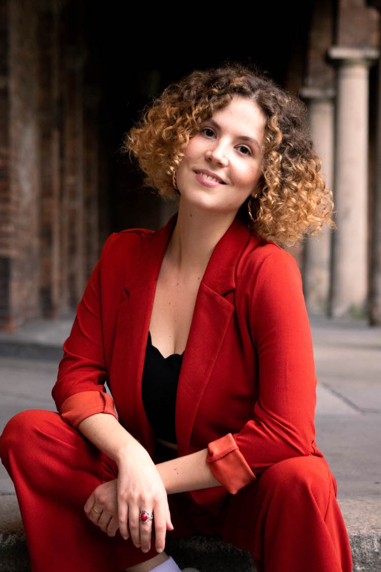 a woman in a red suit and white sneakers