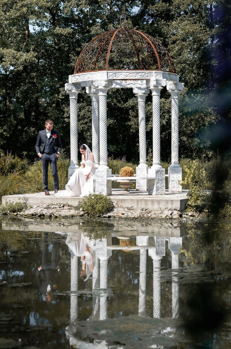 a bride and groom standing in front of a gazeboar
