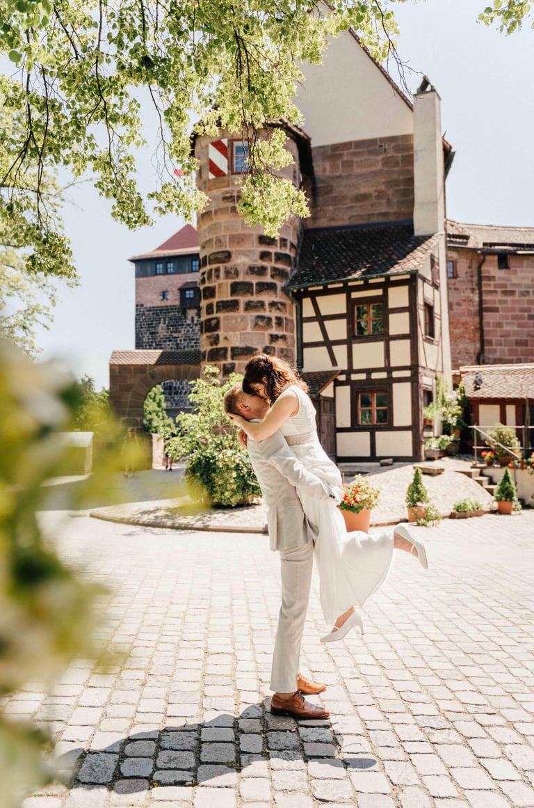 a bride and groom are kissing in front of a large building