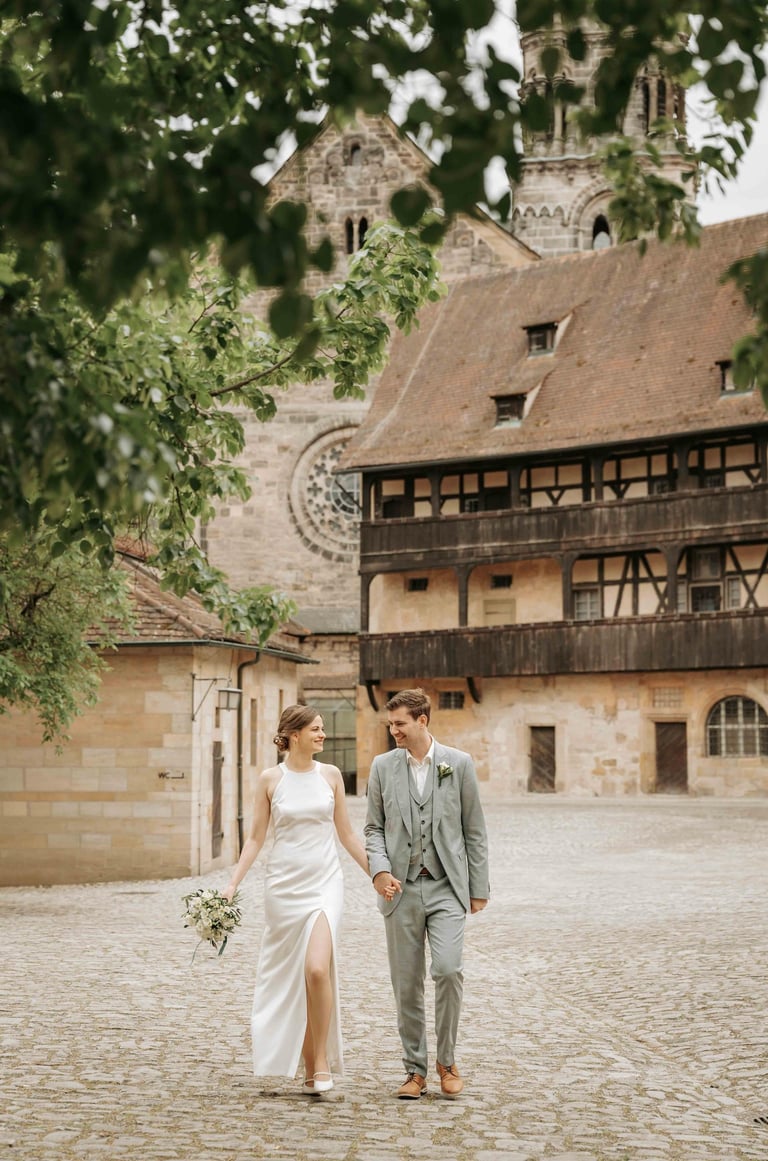 a bride and groom walking down a cobblestone path