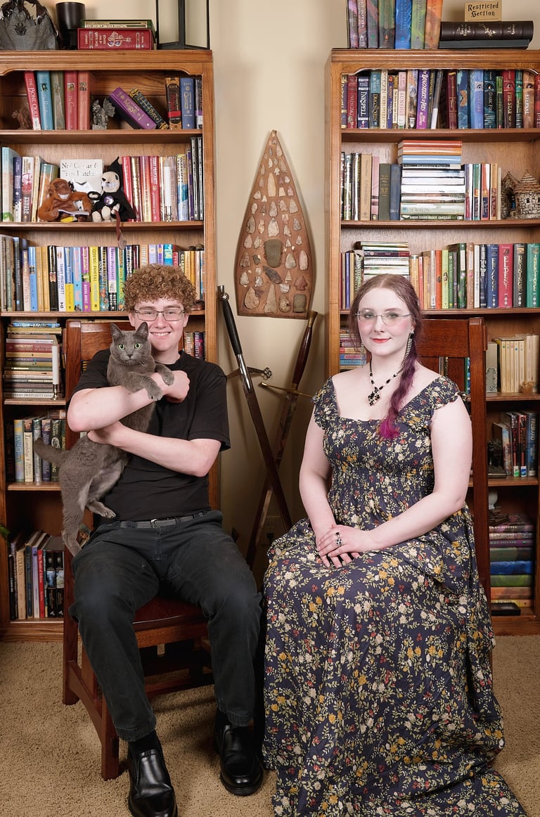 a son with a cat and a daughter sitting on a chair in a library