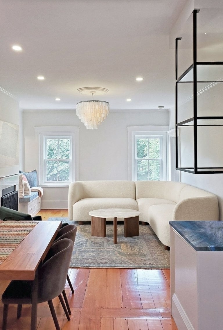 Open plan living area, curved bouclé sectional, capiz chandelier, cobalt quartzite bar, Charlestown Boston