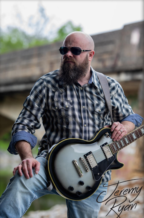 a man with a beard and sunglasses on a guitar