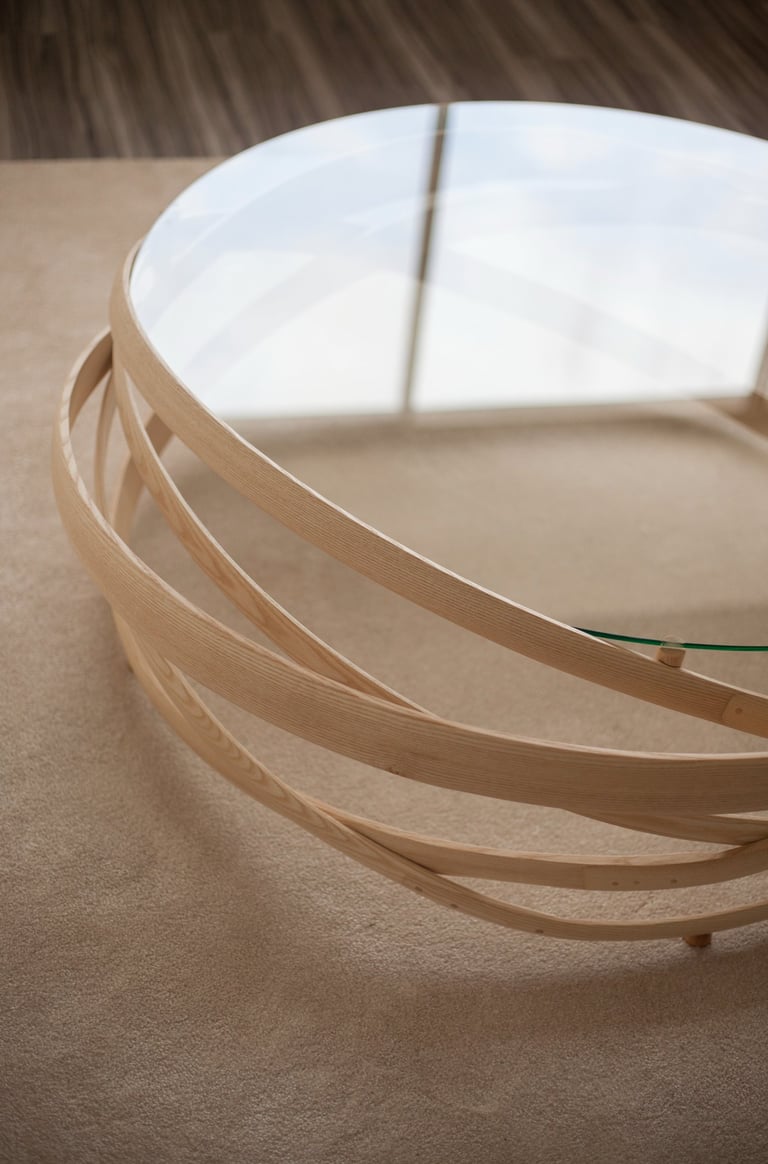 vue de haut d'une grande table basse en lattes de bois étuvé avec un plateau en verre