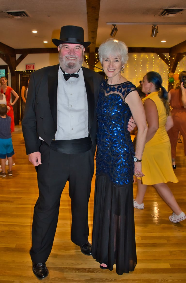 a man and woman in formal attire standing in a dance floor