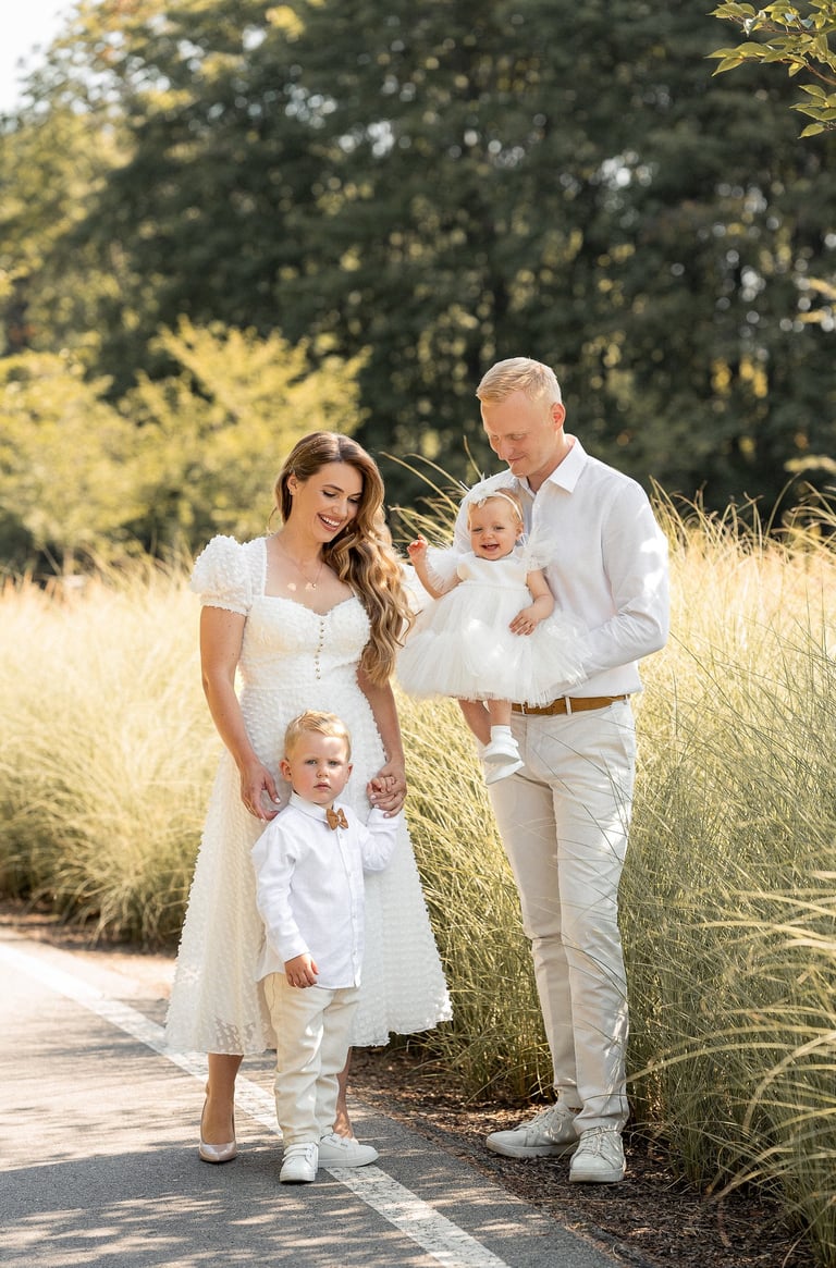 a man and woman holding a baby in a field